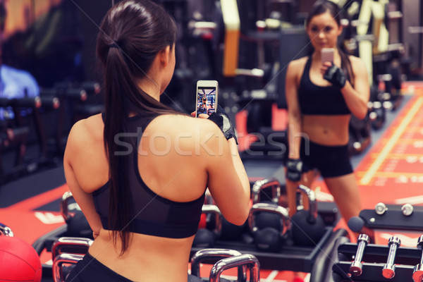 Femeie smartphone oglindă sală de gimnastică sportiv Imagine de stoc © dolgachov