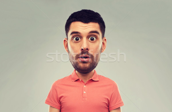 surprised man in polo t-shirt over gray background Stock photo © dolgachov