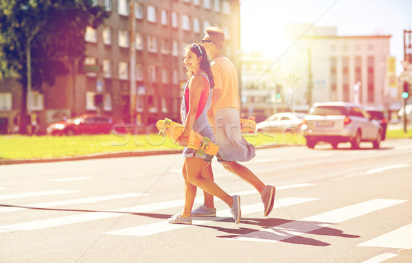 teenage couple with skateboards on city street Stock photo © dolgachov