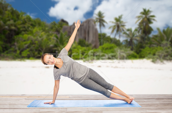 Stock photo: woman doing yoga in side plank pose on beach