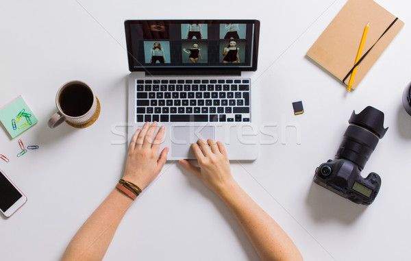 woman hands with camera working on laptop at table Stock photo © dolgachov
