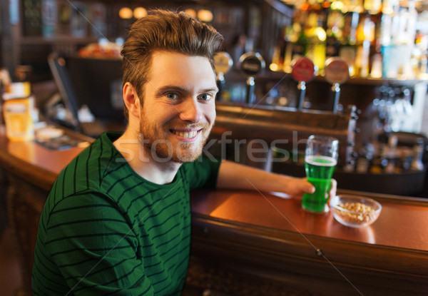 man drinking green beer at bar or pub Stock photo © dolgachov