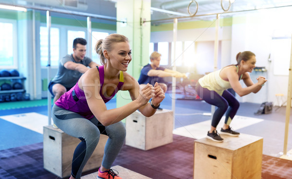 group of people doing box jumps exercise in gym Stock photo © dolgachov