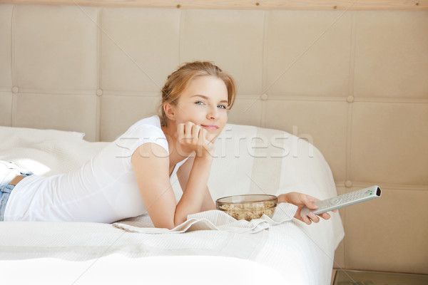 happy teenage girl with TV remote and popcorn Stock photo © dolgachov