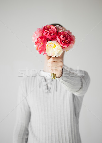 Férfi arc virágcsokor virágok fiatalember kezek Stock fotó © dolgachov