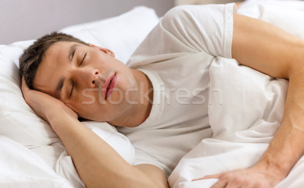 Knappe man slapen bed hotel reizen geluk Stockfoto © dolgachov