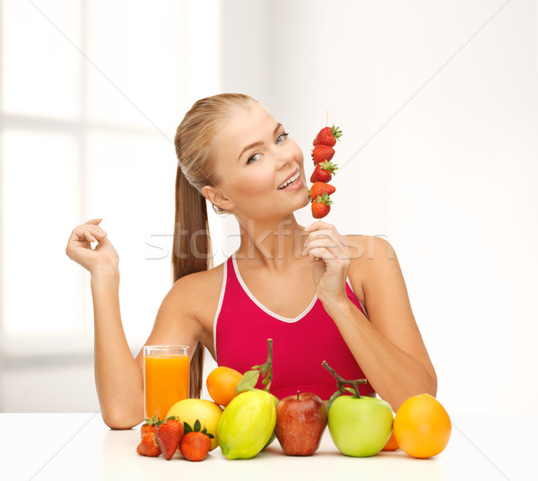 smiling woman with organic food eating strawberry Stock photo © dolgachov