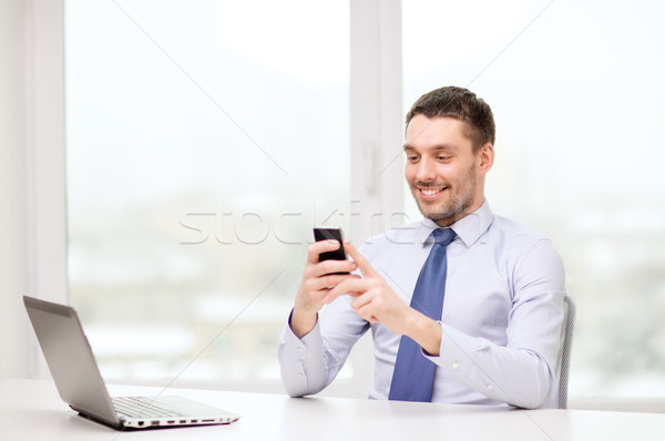 businessman with laptop and smartphone at office Stock photo © dolgachov