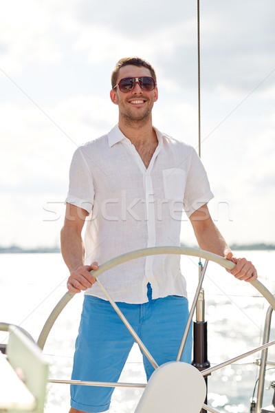 Fiatalember napszemüveg kormánykerék jacht vakáció ünnepek Stock fotó © dolgachov