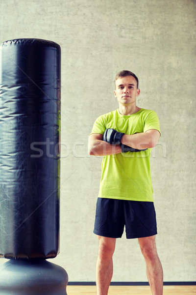 man with boxing gloves and punching bag in gym Stock photo © dolgachov