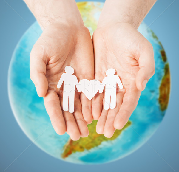 male hands with paper gay couple figures and globe Stock photo © dolgachov