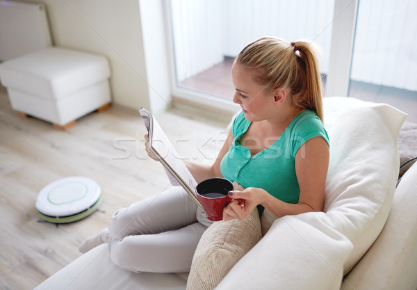 happy woman reading magazine with tea cup at home Stock photo © dolgachov