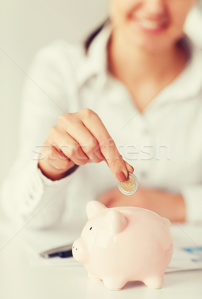 woman hand putting coin into small piggy bank Stock photo © dolgachov