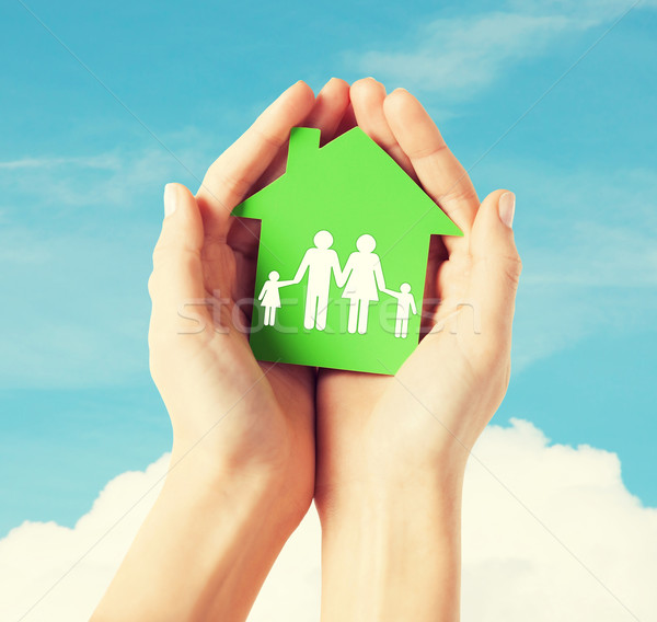 hands holding green house with family Stock photo © dolgachov