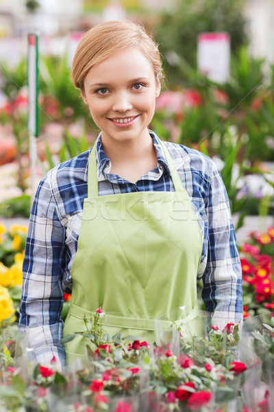 happy woman with flowers in greenhouse Stock photo © dolgachov