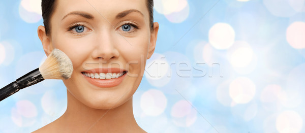 happy woman applying powder foundation with brush Stock photo © dolgachov