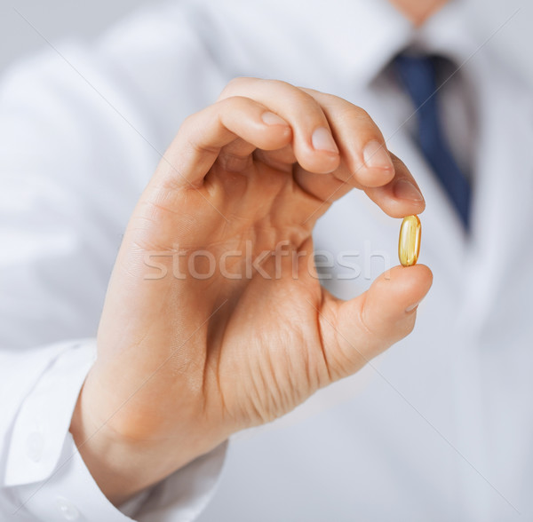 doctor hand showing one capsule Stock photo © dolgachov