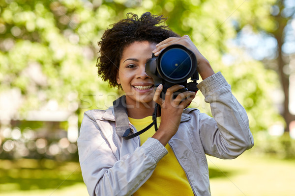 happy african woman with digital camera in park Stock photo © dolgachov