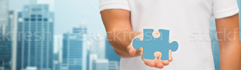 man holding blue puzzle piece over city background Stock photo © dolgachov