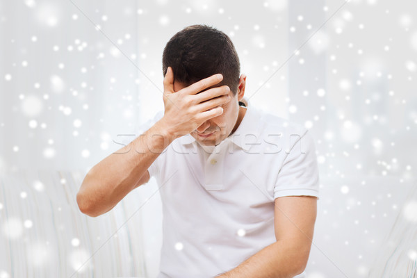unhappy man suffering from head ache at home Stock photo © dolgachov