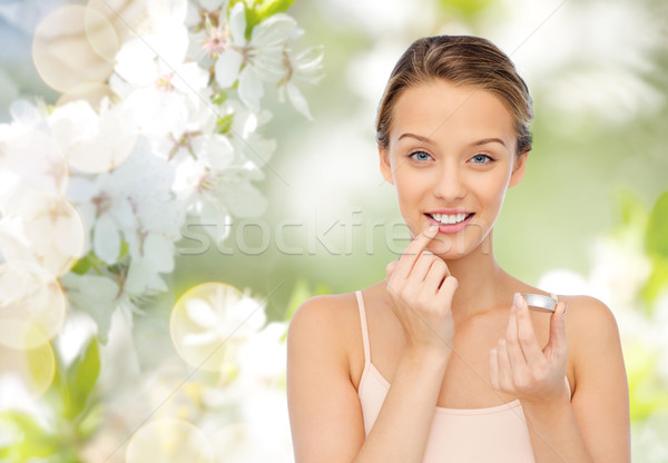 Souriant jeune femme lèvre baume lèvres [[stock_photo]] © dolgachov