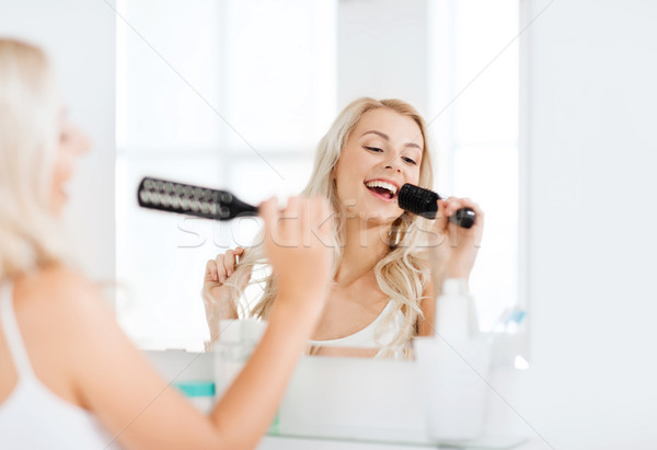 Feliz mulher cantando cabelo escove banheiro Foto stock © dolgachov