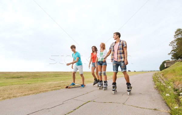 happy teenagers with rollerskates and longboards Stock photo © dolgachov
