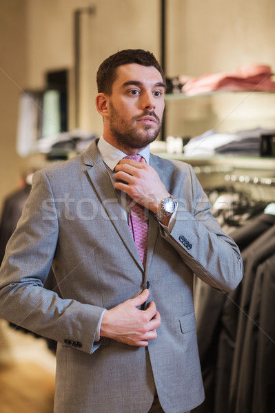 young man trying suit on in clothing store Stock photo © dolgachov