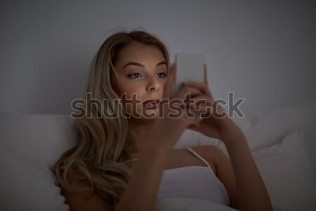 Genç kadın yatak ev yatak odası teknoloji Stok fotoğraf © dolgachov