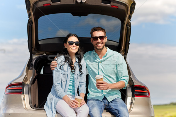 happy couple with coffee at hatchback car trunk Stock photo © dolgachov