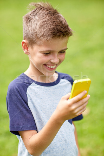 boy with smartphone playing game in summer park Stock photo © dolgachov