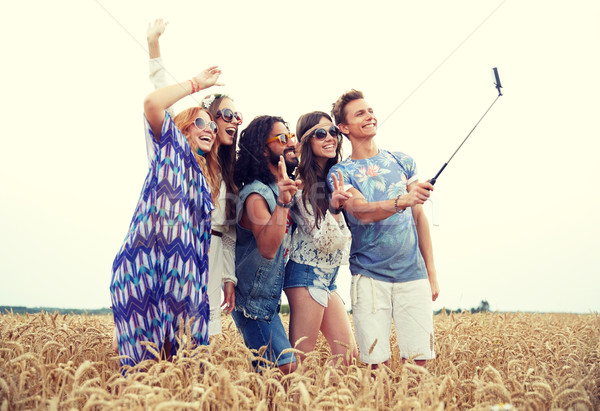 hippie friends with smartphone on selfie stick Stock photo © dolgachov