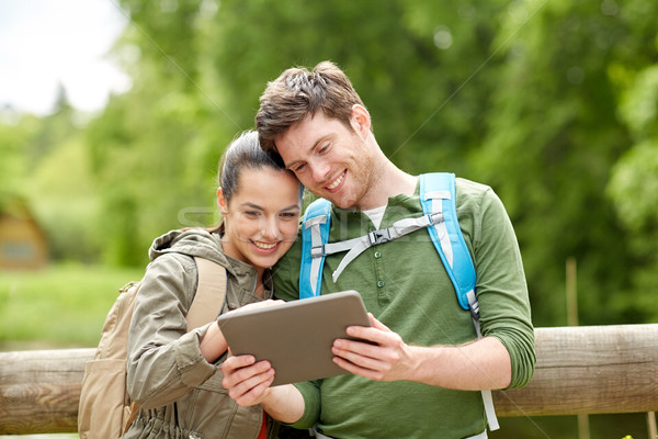 happy couple with backpacks and tablet pc outdoors Stock photo © dolgachov
