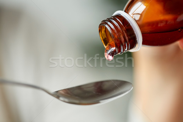 medication or antipyretic syrup and spoon Stock photo © dolgachov
