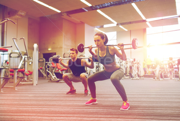 young man and woman training with barbell in gym Stock photo © dolgachov
