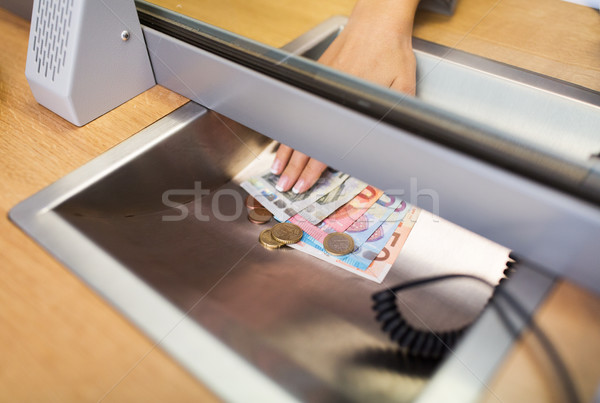 hand with cash money at bank office or exchanger Stock photo © dolgachov