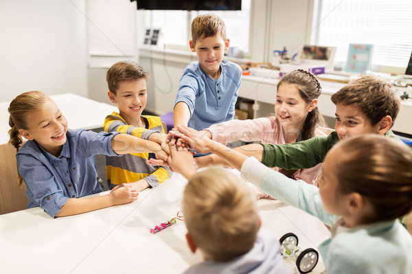 happy children holding hands at robotics school Stock photo © dolgachov