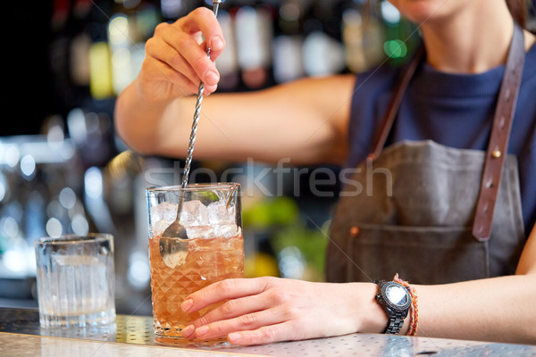 bartender with cocktail stirrer and glass at bar Stock photo © dolgachov