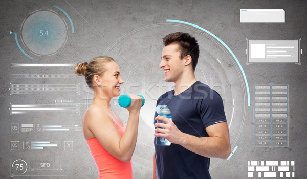 Stock photo: sportive man and woman with dumbbell and water