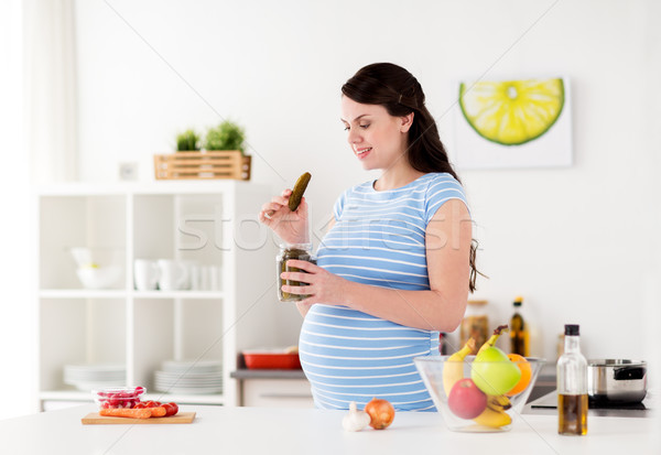 Kobieta w ciąży jedzenie ogórki konserwowe domu kuchnia ciąży Zdjęcia stock © dolgachov