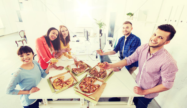Stock photo: happy business team eating pizza in office