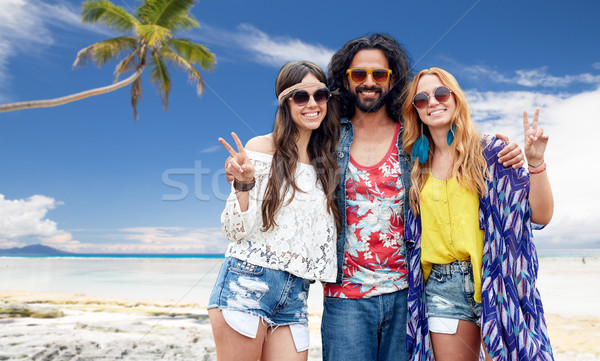 happy hippie friends showing peace on summer beach Stock photo © dolgachov