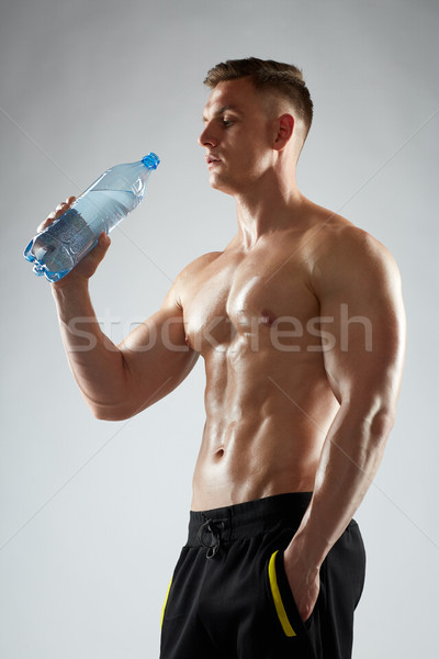 young man or bodybuilder with bottle of water Stock photo © dolgachov