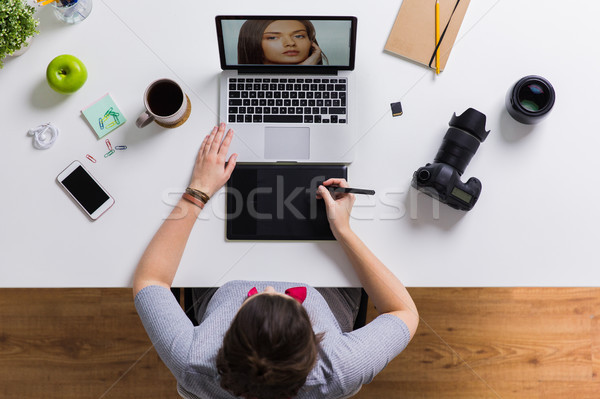 woman with camera working on laptop at table Stock photo © dolgachov