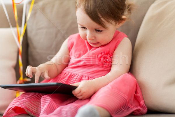 baby girl with tablet pc at home Stock photo © dolgachov