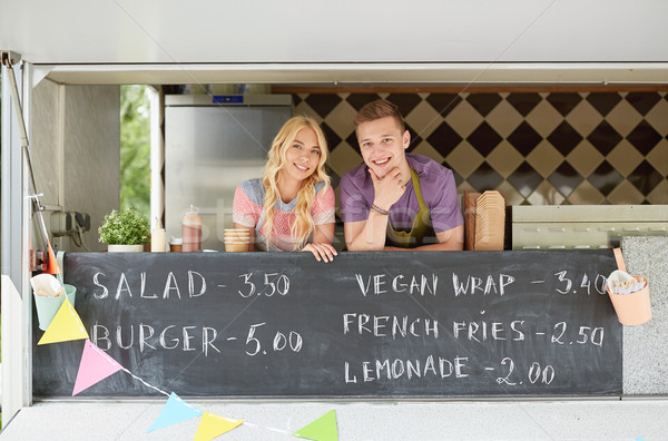 couple of happy young sellers at food truck Stock photo © dolgachov