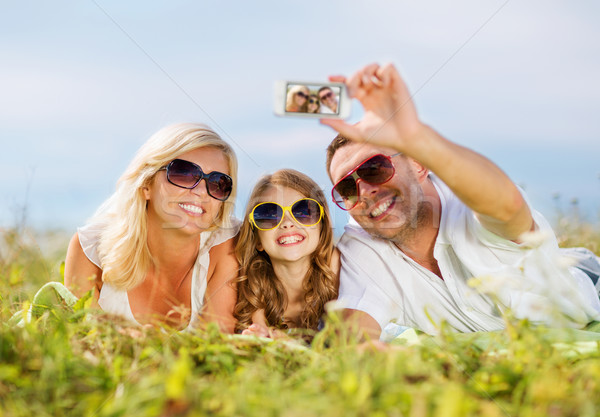 happy family with camera taking picture Stock photo © dolgachov