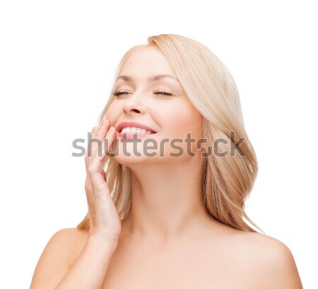 smiling beautiful womant touching her cheek Stock photo © dolgachov