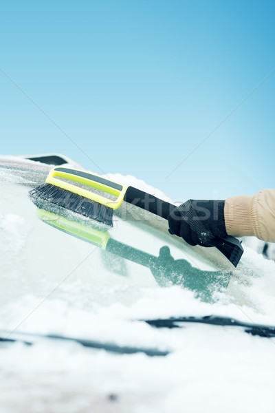 man cleaning snow from car windshield with brush Stock photo © dolgachov