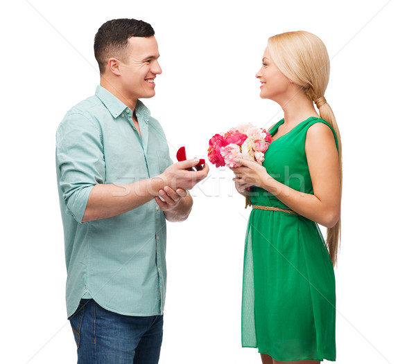 smiling couple with flower bouquet and ring Stock photo © dolgachov